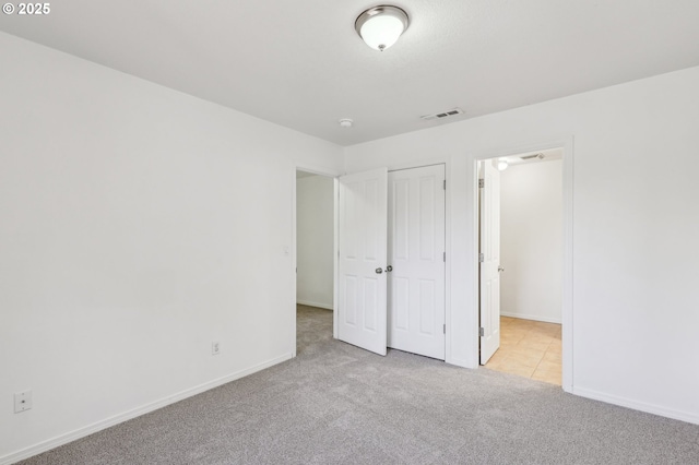 unfurnished bedroom featuring a closet and light carpet