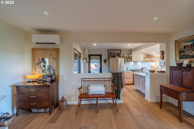interior space with recessed lighting, a wall mounted AC, and light wood-style floors