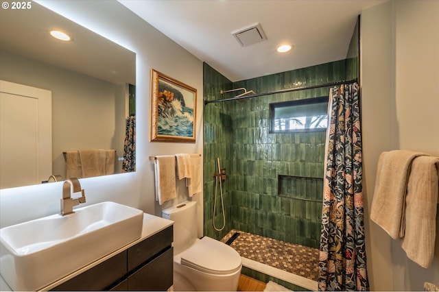 bathroom featuring recessed lighting, visible vents, toilet, vanity, and tiled shower