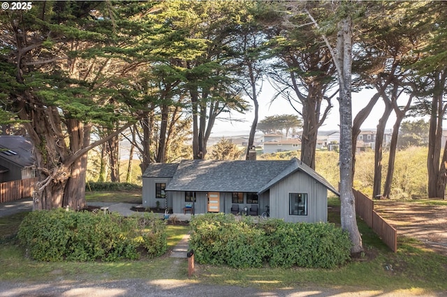 ranch-style home with roof with shingles