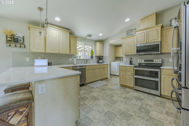kitchen with light brown cabinetry, separate washer and dryer, stainless steel appliances, and a peninsula