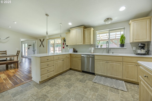 kitchen with a sink, light brown cabinetry, a healthy amount of sunlight, and dishwasher
