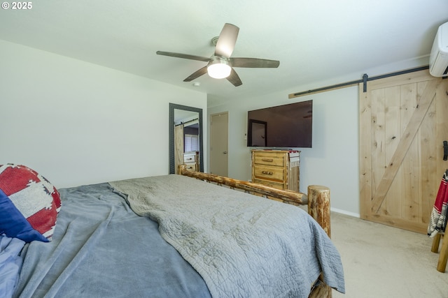bedroom with a ceiling fan, light colored carpet, and a barn door