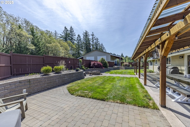 view of yard with a fenced backyard, a patio, and a fire pit