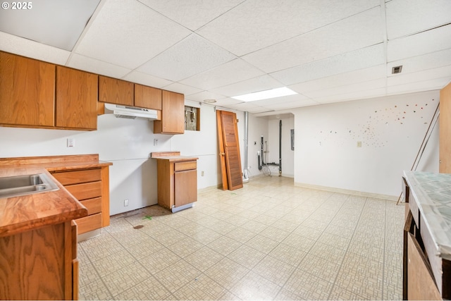 1339 SW 27th Ct, Gresham, OR 97080 - kitchen with a paneled ceiling, brown cabinetry, a sink, and under cabinet range hood