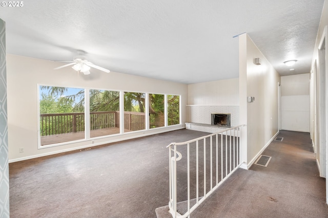 1339 SW 27th Ct, Gresham, OR 97080 - unfurnished living room with carpet flooring, ceiling fan, a fireplace, baseboards, and a textured ceiling