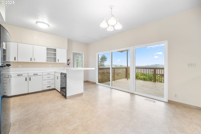 1339 SW 27th Ct, Gresham, OR 97080 - kitchen with a peninsula, a chandelier, light countertops, open shelves, and white cabinets