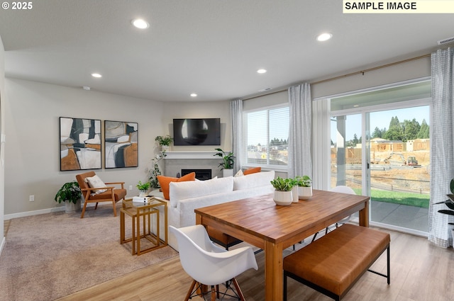 dining space featuring recessed lighting, a fireplace, baseboards, and light wood-type flooring
