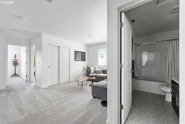 corridor with a textured ceiling, carpet, and visible vents