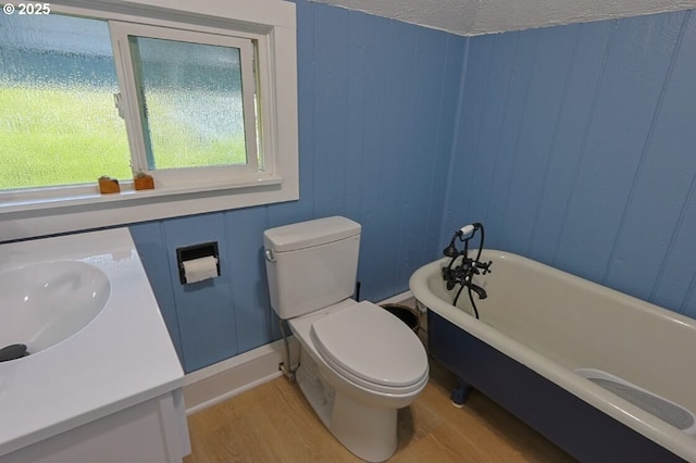 929 S 7th St, Coos Bay, OR 97420 - bathroom with wood finished floors, a freestanding tub, toilet, vanity, and a decorative wall