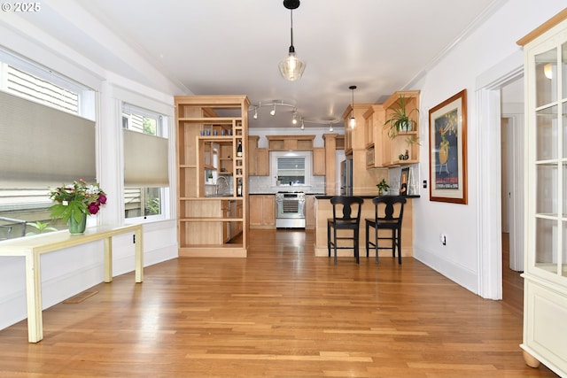 1330 SE 14th Ave SE, Portland, OR 97214 - kitchen with open shelves, stainless steel appliances, a breakfast bar area, a peninsula, and light wood-style floors