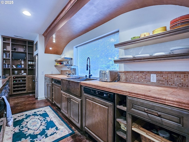 kitchen featuring dark brown cabinets, open shelves, baseboards, stainless steel fridge, and a sink