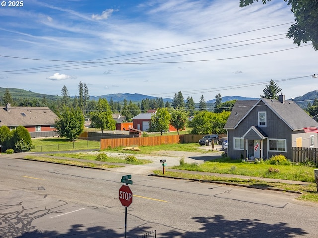 410 E Yacolt Rd, Yacolt, WA 98675 - view of asphalt road with sidewalks, a mountain view, traffic signs, and curbs