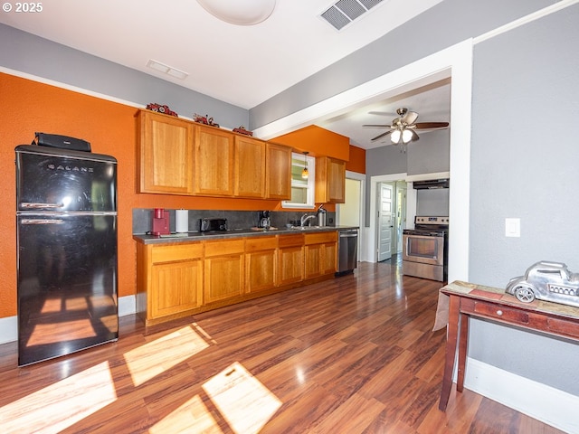 410 E Yacolt Rd, Yacolt, WA 98675 - kitchen featuring appliances with stainless steel finishes, ceiling fan, brown cabinetry, dark wood-type flooring, and dark countertops