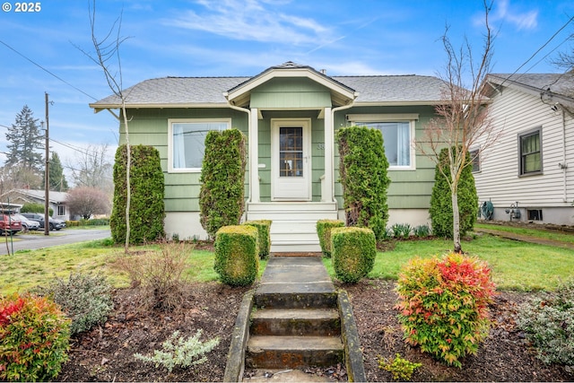 bungalow with roof with shingles and a front yard