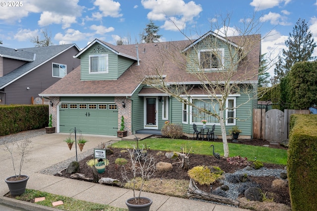 view of front of house featuring a shingled roof, concrete driveway, a gate, a garage, and a front lawn