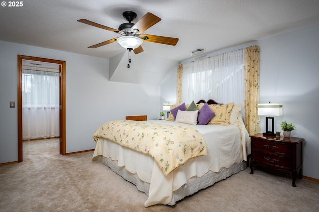 carpeted bedroom with ceiling fan and a textured ceiling