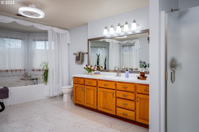 bathroom featuring a relaxing tiled tub, vanity, and toilet