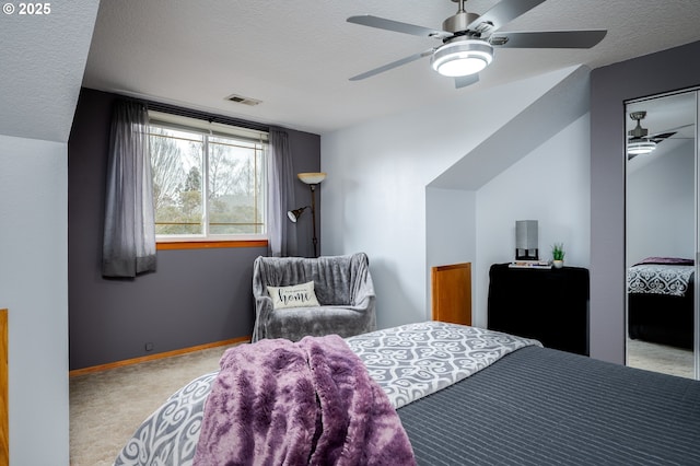 carpeted bedroom featuring ceiling fan and a textured ceiling