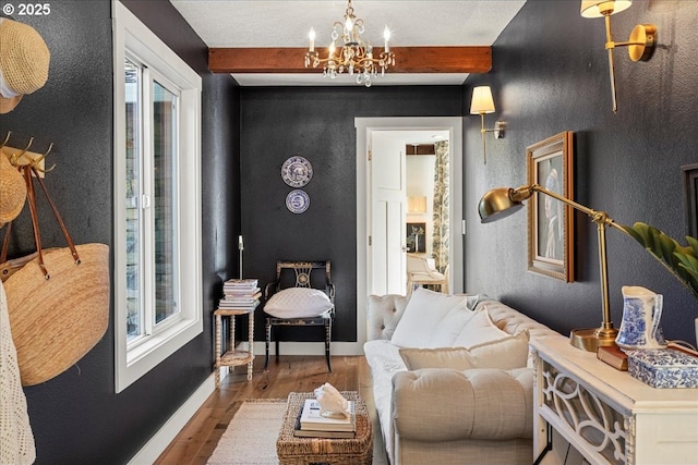 living area with beamed ceiling, a notable chandelier, and hardwood / wood-style floors