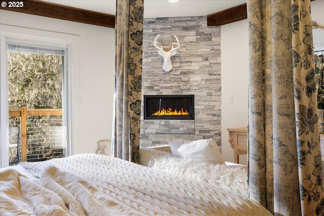 bedroom with beam ceiling and a fireplace