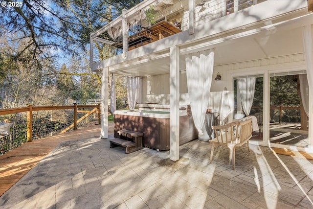 view of patio featuring a wooden deck and a hot tub