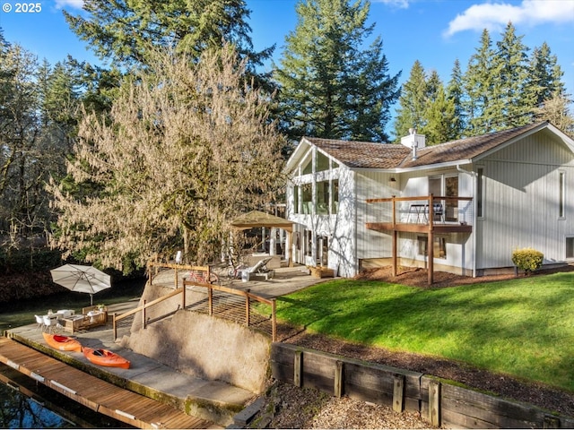 back of house with a yard, a balcony, and a patio