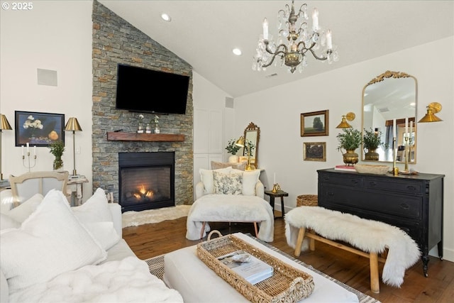 living room with a fireplace, wood-type flooring, an inviting chandelier, and lofted ceiling