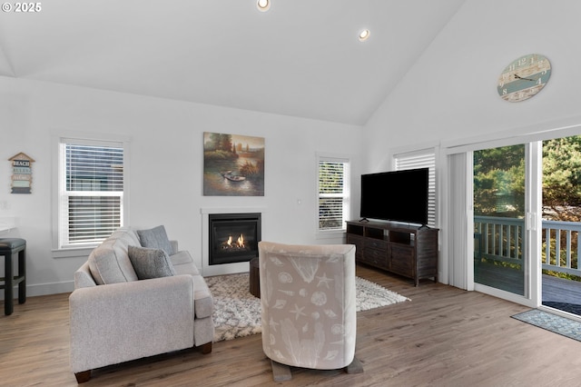 5769 NW Logan Rd, Lincoln City, OR 97367 - living room featuring a glass covered fireplace, high vaulted ceiling, wood finished floors, recessed lighting, and baseboards