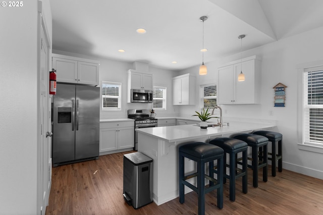5769 NW Logan Rd, Lincoln City, OR 97367 - kitchen featuring stainless steel appliances, a peninsula, a sink, a kitchen bar, and light countertops
