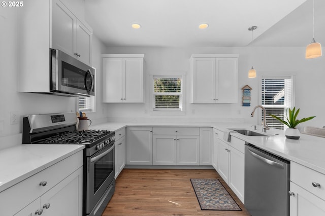 5769 NW Logan Rd, Lincoln City, OR 97367 - kitchen with stainless steel appliances, a sink, white cabinetry, light countertops, and recessed lighting