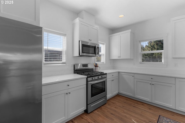 5769 NW Logan Rd, Lincoln City, OR 97367 - kitchen with stainless steel appliances, white cabinets, dark wood finished floors, and recessed lighting