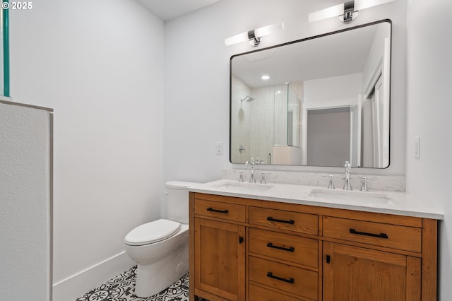 bathroom with a shower stall, double vanity, a sink, and toilet