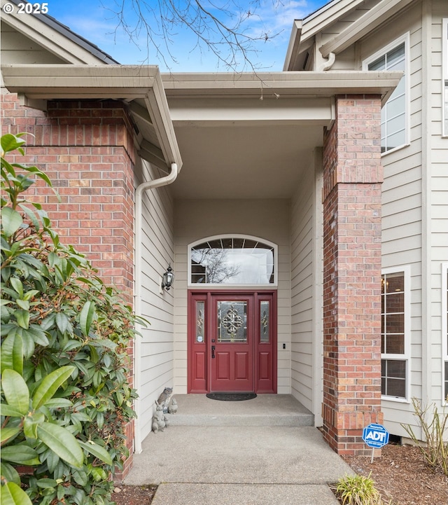 view of exterior entry with brick siding