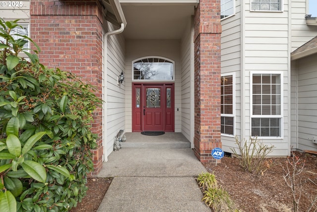 view of exterior entry featuring brick siding