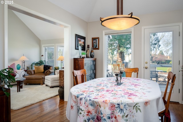 dining room featuring dark wood-style floors, lofted ceiling, and plenty of natural light