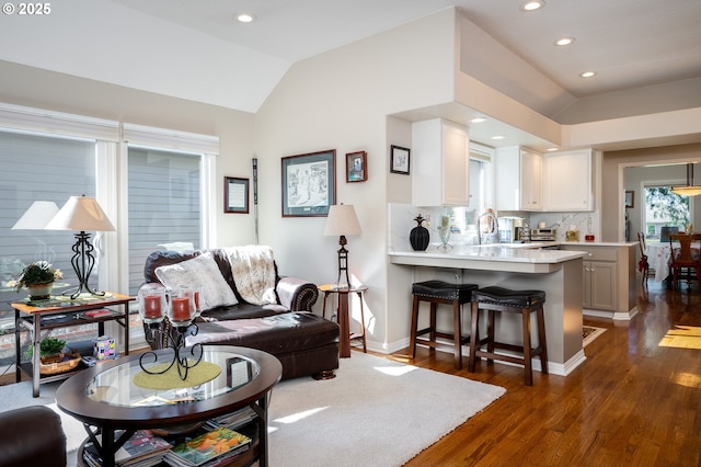 living area featuring dark wood-style floors, baseboards, vaulted ceiling, and recessed lighting