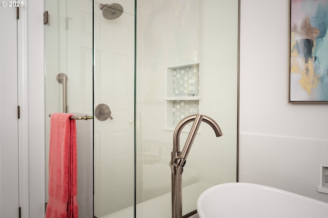 full bath featuring a shower stall and a freestanding bath