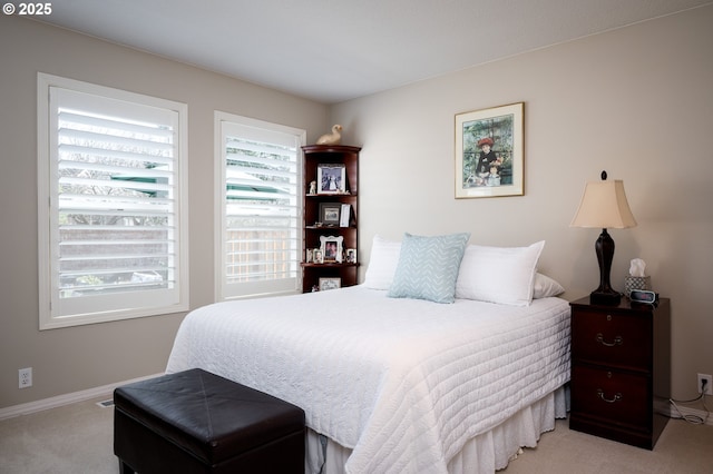 bedroom with baseboards, multiple windows, and carpet flooring