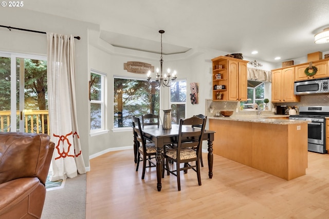 dining space featuring light wood-type flooring and a chandelier