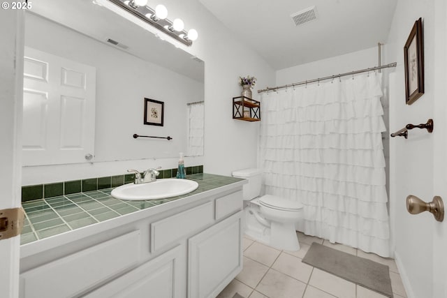 bathroom featuring walk in shower, vanity, toilet, and tile patterned flooring