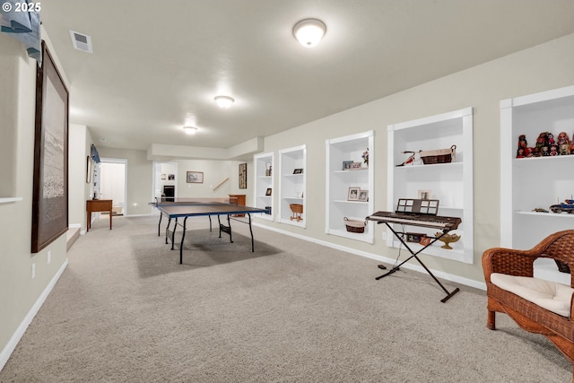 playroom featuring built in shelves and light colored carpet