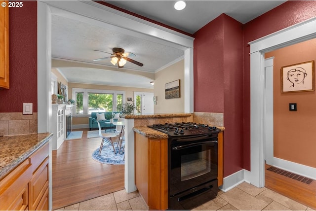 7406 N Fiske Ave, Portland, OR 97203 - kitchen with black gas range oven, crown molding, open floor plan, backsplash, and light stone counters