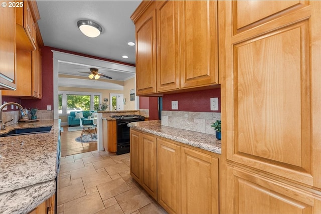 7406 N Fiske Ave, Portland, OR 97203 - kitchen featuring black range oven, light stone counters, a ceiling fan, stone tile flooring, and recessed lighting