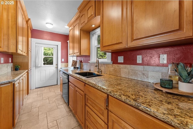 7406 N Fiske Ave, Portland, OR 97203 - kitchen featuring healthy amount of natural light, light stone countertops, dishwashing machine, and stone tile floors