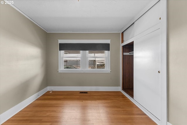 7406 N Fiske Ave, Portland, OR 97203 - unfurnished bedroom with crown molding, light wood-style floors, and a closet