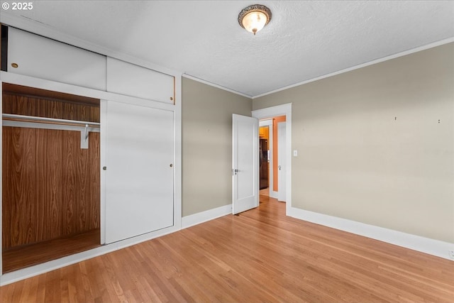 7406 N Fiske Ave, Portland, OR 97203 - unfurnished bedroom with wood finished floors, ornamental molding, a closet, and a textured ceiling