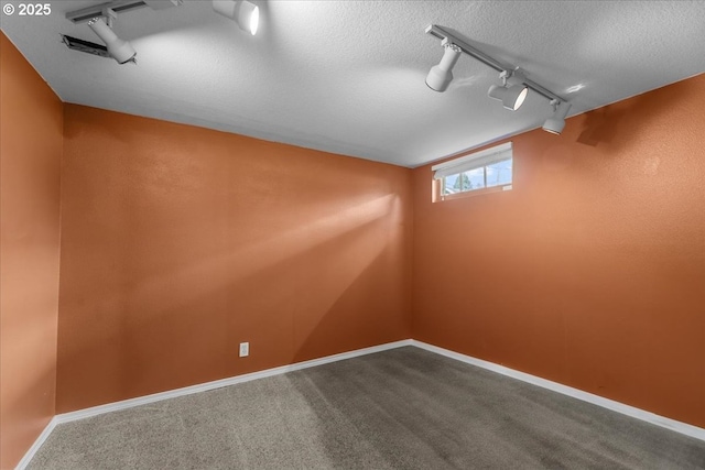 7406 N Fiske Ave, Portland, OR 97203 - below grade area featuring track lighting, dark colored carpet, and a textured ceiling