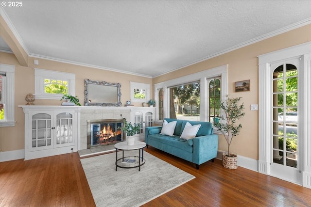 7406 N Fiske Ave, Portland, OR 97203 - living room featuring wood finished floors, a tile fireplace, ornamental molding, and a textured ceiling