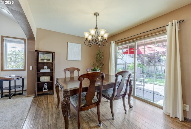 dining room featuring a notable chandelier, plenty of natural light, and light wood-type flooring